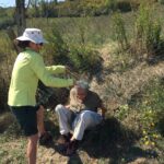 (50) Cathie Helping Franca Burgisser under Fence at Her Estate in Tuscany