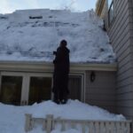 Peter Raking the Roof from all the Snow that Fell (at least 3' in a week) when Cathie and Celeste were on one of their Jamaican Yoga Retreats Medium